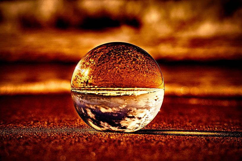 View through the glass ball on the beach. Sea and sky in background by Martin Köbsch
