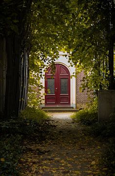 Porte rouge cachée derrière des arbres sur Jelle Terlouw