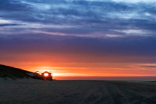 Afgelegen strandhuis met uitzicht op zee bij zonsondergang
