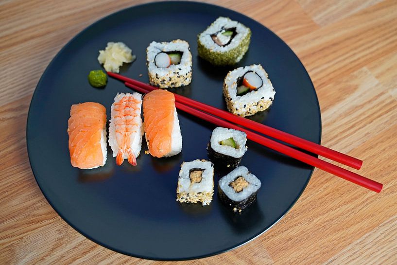 Sushi disposés sur une assiette avec des baguettes. par Babetts Bildergalerie