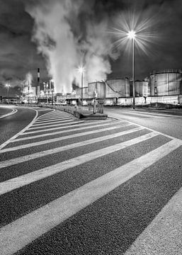 Beleuchtete Straße in der Nacht mit Markierungen und Raffinerie in Antwerpen