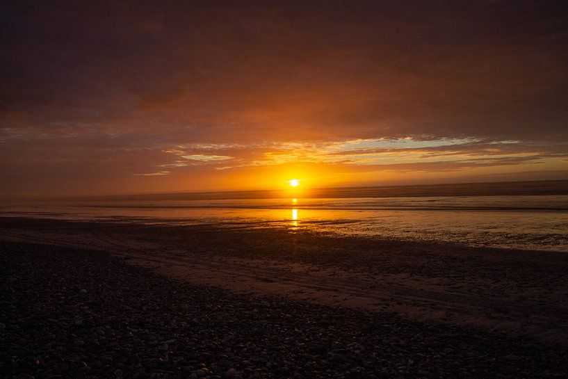 sunset on the beach and the sun just above the horizon by Marco Leeggangers