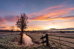 Prachtige landschapsfoto met roze oranje zonsopgang tijdens de winter van Dafne Vos