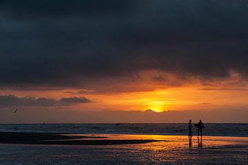 Surfers - zonsondergang van Dick van Duijn