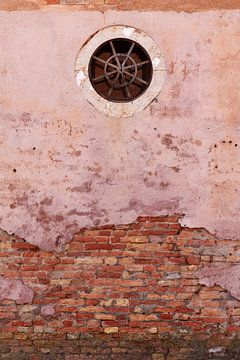 Roze vergane muur met een klein rond raam en gietijzerwerk uit Venetië