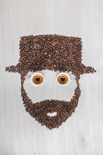 Authentieke Koffiemomenten: Twee Koffiekopjes met Koffiebonen en Charmante Man met Baard