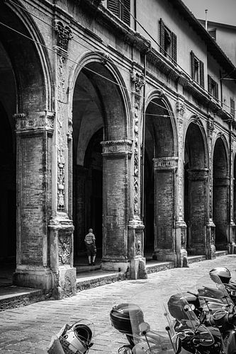 Man loopt door portici in Bologna, Itali&euml;