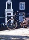 Fiets op brug Amsterdam van Studio LINKSHANDIG Amsterdam thumbnail