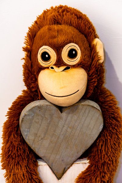 A cloth monkey hangs from a heart of wood by Tom Voelz
