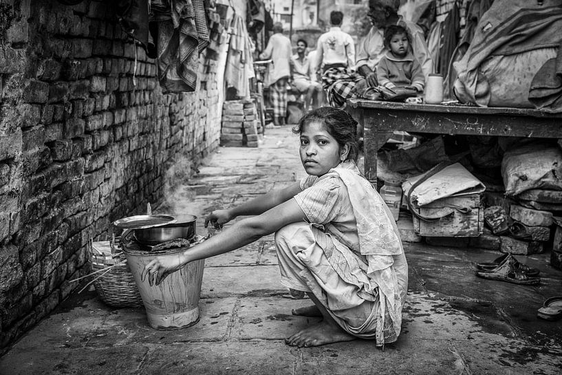 Meisje doet de was  in achterbuurt van Varanasi in India van Wout Kok