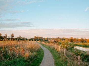 Zonsondergang bij een zandpad tussen de weilanden langs de Berkel
