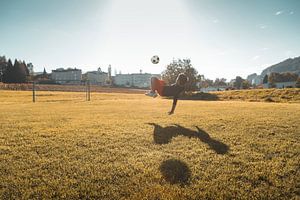 Coup de pied aérien de football dans la lumière du soir
