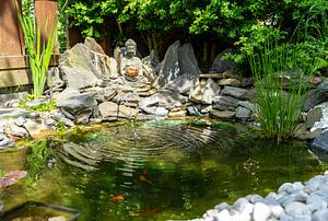 Buddha-Statue im japanischen Steingarten mit Gartenteich