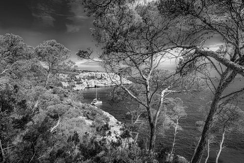 Eenzame baai op Mallorca met zeilboot. Zwart-wit beeld.