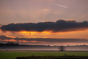 Zonsondergang in Noord-Brabant met wat mistbanken in de verte. van Magalie Sebregts