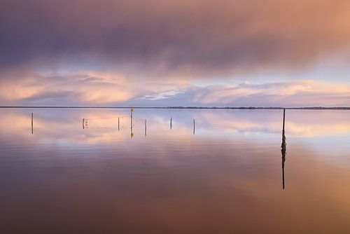 Dramatische wolkenluchten boven het Lauwersmeer tijdens de zonso