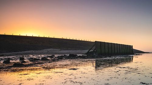 Zeewering bij Vatrop (Wieringen) door kleur omgeven tijdens zonsondergang