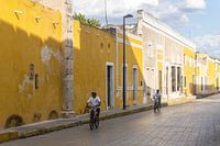 Cyclists in the yellow city of Izamal in Mexico