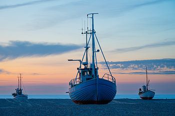 Boten op het strand na zonsondergang