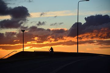 Scooterrijder tijdens zonsondergang van Jurjen Jan Snikkenburg