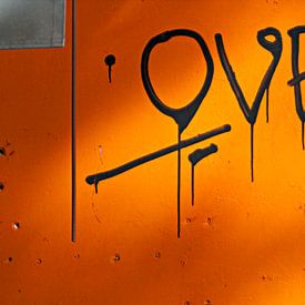 Liefdevolle grafitti op oranje muur van Maerten Prins