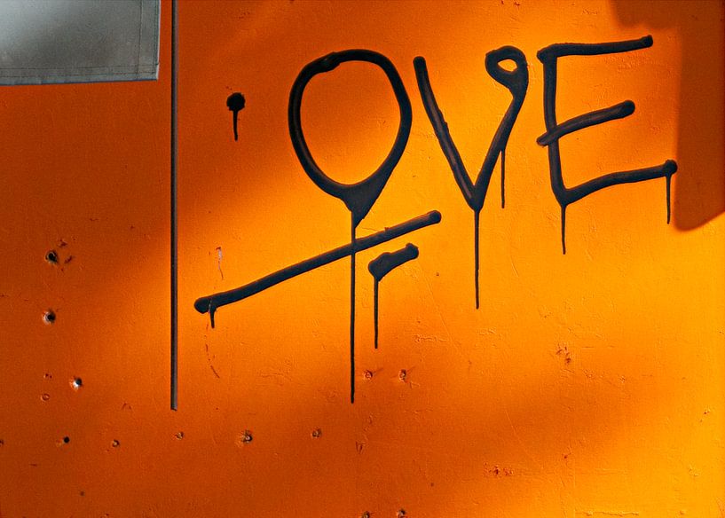 Liefdevolle grafitti op oranje muur van Maerten Prins