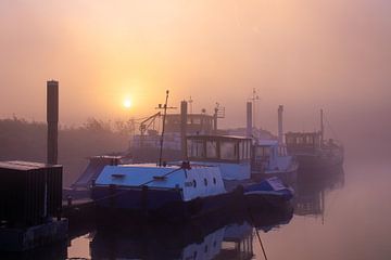 Een mistige zonsopkomst aan het water met mooie boten van Rick van de Kraats