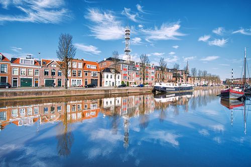De Oosterkade in Leeuwarden weerspiegeld in de stadsgracht. sur Harrie Muis