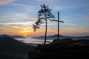 Der Rötzenfels, eine Landschaftsaufnahme von einem Sandsteinfelsen mit Kreutz und Baum, Sonnenaufgan