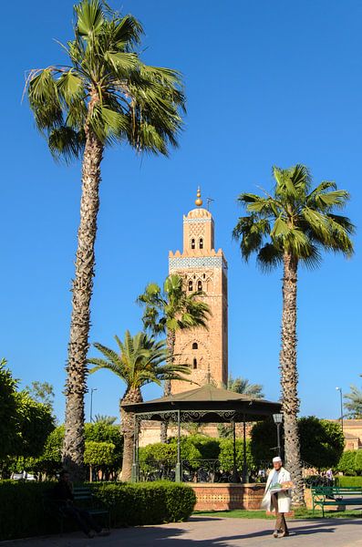 Gebakjesverkoper in park met palmbomen voor minaret Koutoubia moskee in Marrakech Marokko van Dieter Walther
