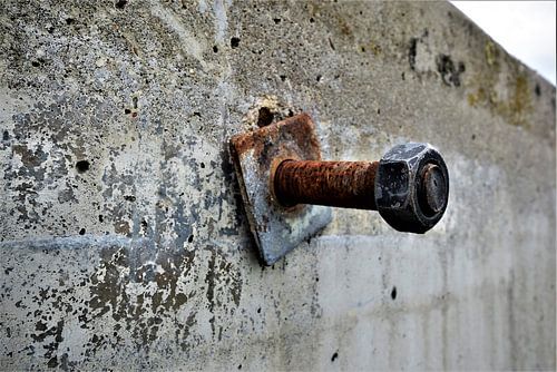 Roestige schroef in betonnen muur
