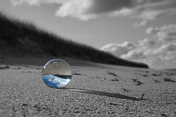 Glaskugel am Strand der Ostsee. Schwarz-Weiß-Foto mit einer farbigen Glaskugel in der die Landschaft von Martin Köbsch