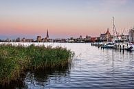 Uitzicht over de Warnow naar de Hanzestad Rostock in de avond van Rico Ködder thumbnail