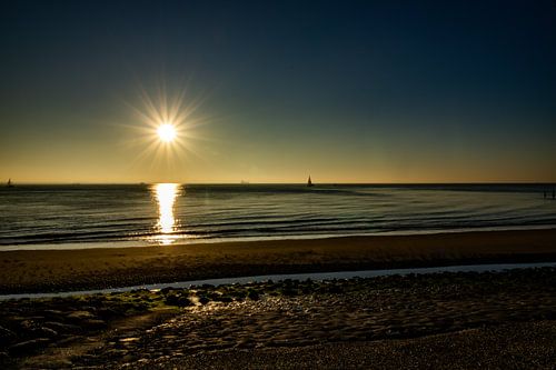 Sunset at the Dutch coast with a sailboat