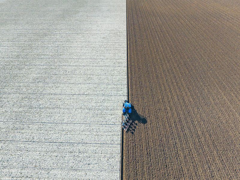Tractor ploegt de grond voor het planten van gewassen  van Sjoerd van der Wal Fotografie