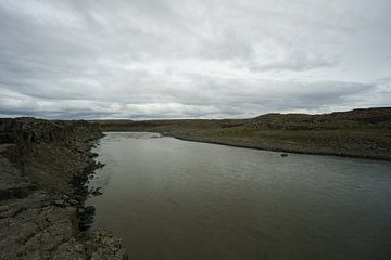 IJsland - Brede rivier voor detifoss waterval in steenachtig gebied van adventure-photos