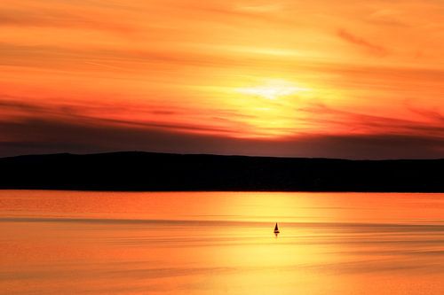 Eenzame zeilboot op het Balatonmeer bij zonsondergang