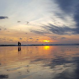 Romantisch koppel kijkt naar de kleurrijke zonsondergang in Bali van Mireille Zoet