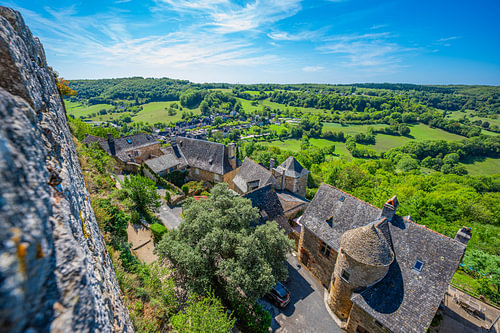 Hilltop village rooftops above green valley in southern France