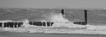 Golfbrekers met opspattend water aan Nederlandse kust zwart wit