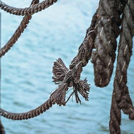 Knoten an einem alten Schiffstau auf einem Steg über dem Wasser, Metapher für von Maren Winter