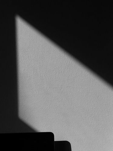 Der Schatten erzeugt eine geometrische Form an der Wand