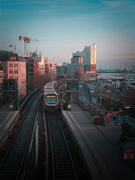 Hamburger Landungsbrücken mit Elbphilharmonie – Stadtbild bei Sonnenuntergang von Florian Wübbe