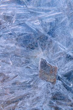 Kleurige steen onder gebroken ijs in Noorwegen. van Jos Pannekoek
