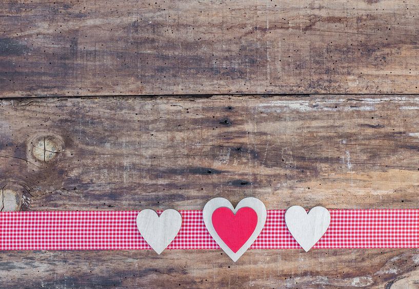 Three love hearts on wood background with red ribbon border decoration by Alex Winter