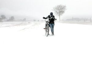 Mädchen mit Fahrrad im Schneesturm in Zeeland