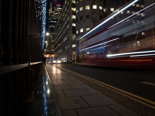 Typische hop-on-hop-off bus rijdend door Canary Wharf