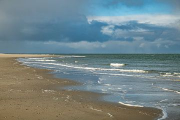 the beach of the island of Texel with dark clouds in the background and small waves in the surf by ChrisWillemsen