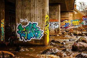 Graffiti unter der Brücke – Fluss & Felsen im Warmlicht