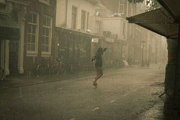 Junge Frau tanzt im Regen von Bart van Lier